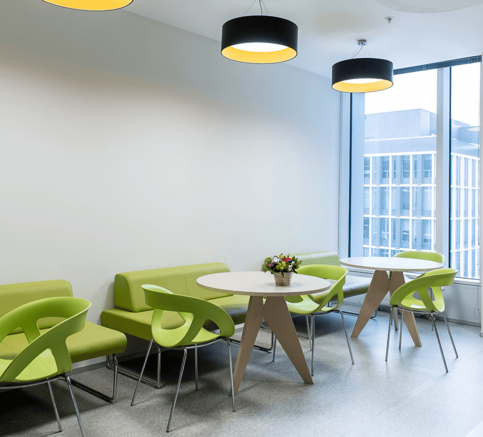 Office lounge with green chairs and tables